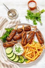 minced beef skewers with potato fries on plate