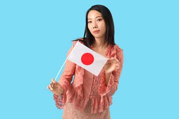 Young Asian woman with flag of Japan on blue background