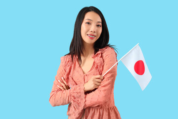 Young Asian woman with flag of Japan on blue background