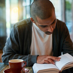 Man, coffee and reading book at cafe in table for reading novel or story for knowledge. Restaurant,...