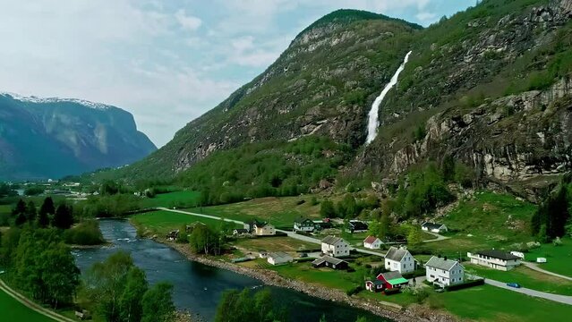 Aerial view of a river, houses and a waterfall, sunny day in Flam, Norway
