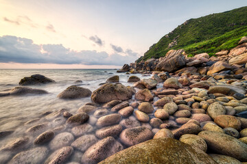 Sunrise sea view on pebble beach. Location: Wanning, Hainan, China.