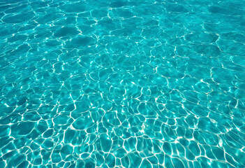 Beautiful turquoise blue ocean water surface with light reflections and highlights. Texture of water close-up macro
