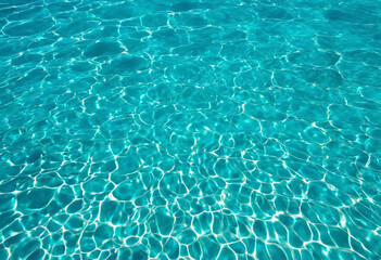 Beautiful turquoise blue ocean water surface with light reflections and highlights. Texture of...