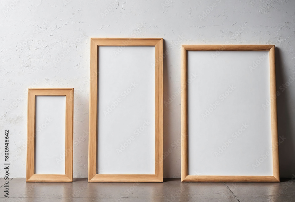 Fototapete close up of clean simple white blank frames with wooden frames of different sizes hanging up on a wa