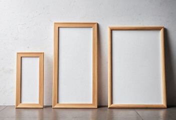 Close up of clean simple white blank frames with wooden frames of different sizes hanging up on a wall, bright lighting industrial feel - Mockup