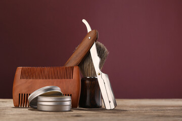 Moustache and beard styling tools on wooden table. Space for text