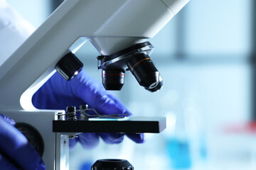 Scientist working with modern microscope indoors, closeup