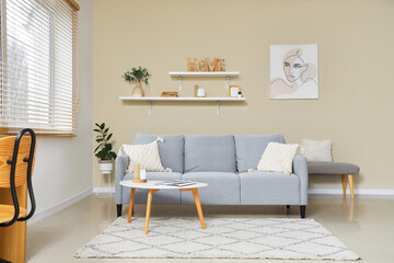 Interior of stylish living room with sofa, table and shelves