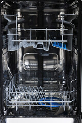 Open clean empty dishwasher machine, closeup. Home appliance