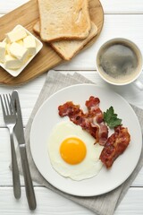 Delicious breakfast with sunny side up egg served on white wooden table, flat lay