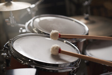 Drum, kit and performance of music on instrument for concert with creativity and talent. Stage, drums and drumsticks for drummer in rock band to play rehearsal of festival or musical event in theatre