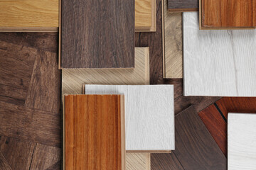 Different samples of wooden flooring as background, flat lay
