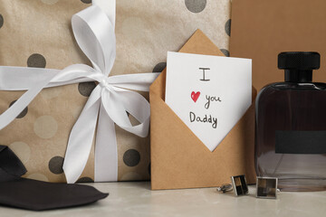 Happy Father's Day. Card with phrase I Love You, Daddy in envelope, cufflinks, perfume and gift box...