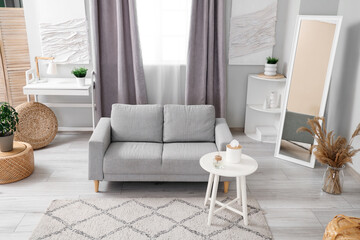 Light living room with grey sofa, coffee table and window