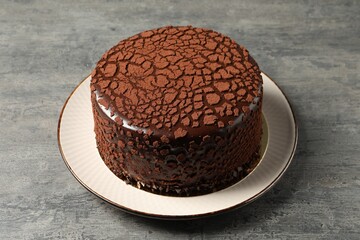 Delicious chocolate truffle cake on grey textured table