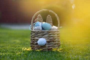 Easter eggs in basket in grass. Traditional egg hunt for spring holidays
