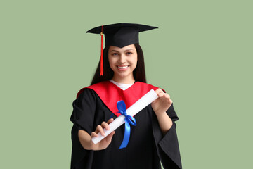 Happy female graduate with diploma on green background