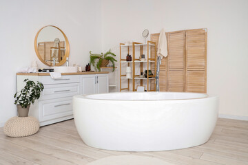 Interior of light bathroom with bathtub, sink and mirror