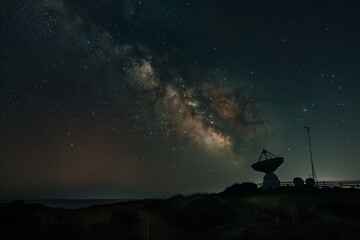 photo against the backdrop of a star-studded sky, an observatory and a satellite dish emerge from the darkness, their surroundings transformed by the ethereal glow of the night,