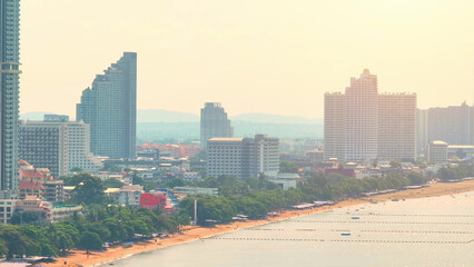 Obraz premium Evening Splendor: As the sun dips below the horizon, Jomtien Beach transforms into a captivating canvas of vibrant oranges, casting a spellbinding spell. Pattaya, Thailand. Aerial view drone. 