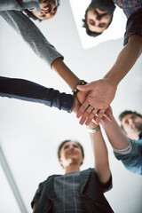 Hands, huddle and motivation with design people in office from below for collaboration, support or trust. Goals, target and unity with palm of designer group closeup in workplace for team building