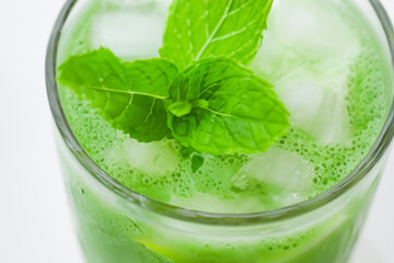 mint drink. fresh green mint lies on top in a transparent glass with water and ice, top view, drink concept
