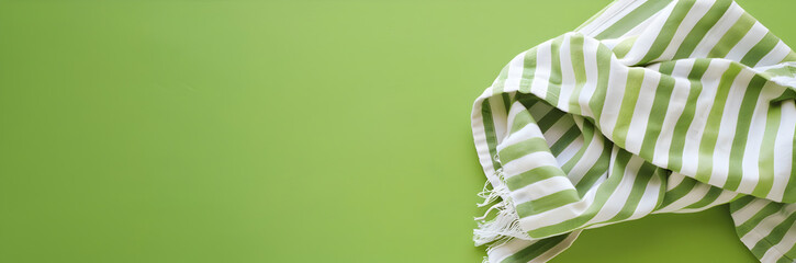 Striped towel web banner. Striped towel isolated on green background with copy space.