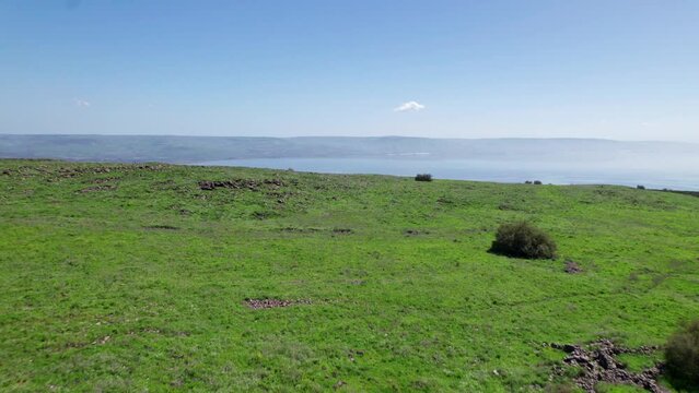 Drone shot of the Sea of Galilee revealed behind green hills