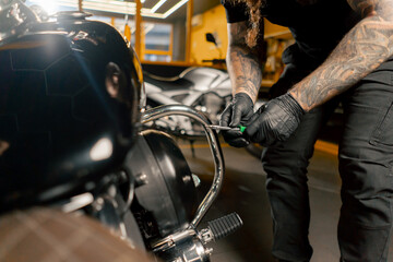 In a motorcycle repair shop master repairs a motorbike and updates fuel supply systems