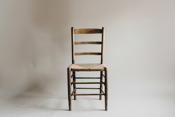 A traditional ladderback chair with a clean white backdrop.