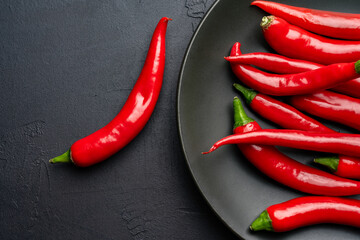 Red and hot Chili pepper on black background