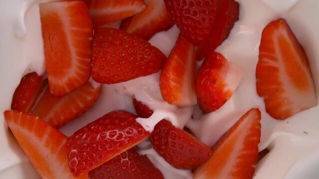 Super Slow Motion Shot of Fresh Strawberries Followed by Camera Falling into Yogurt at 1000fps.