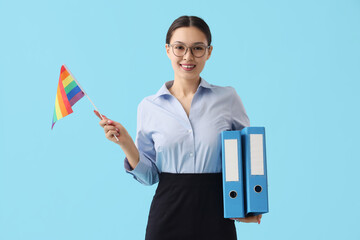 Asian businesswoman with LGBT flag and folders on blue background