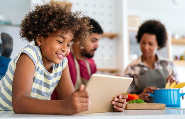 Happy african american parents and child having fun preparing healthy food in kitchen