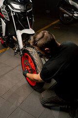 In a motorbike repair shop suspension system for a motorbike is repairing the front wheel