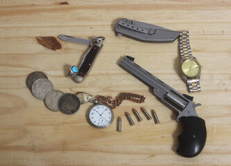 Gun With Silver Coins and Pocket Watch on Wooden Table - Powered by Adobe