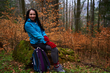 Woman hiker on a rainy day in the forest - 800985062