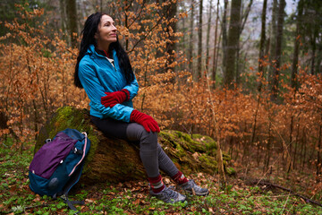 Woman hiker on a rainy day in the forest - 800985071