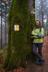 Woman hiker on a rainy day in the forest - 800985281