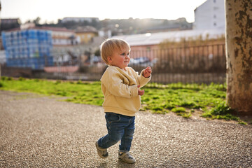 A little baby boy walking in a city park