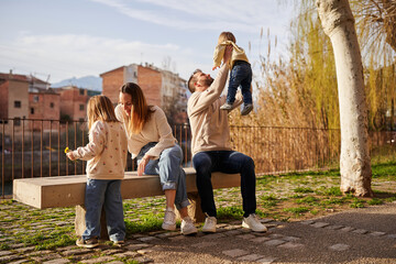 Young family spending time together on a park bench