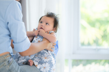 A mother plays with her little daughter in a bedroom full of warmth and family.