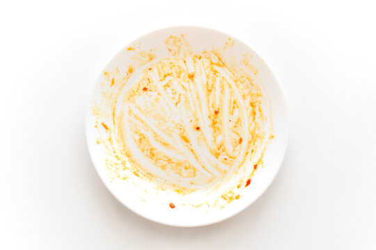 Dirty plate with sweet and chilli sauce stains food leftover on the table. How to clean dishes after finish eating. 