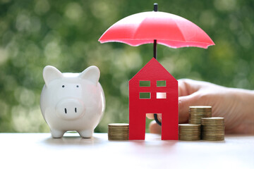 Protection, Model house and piggy bank with the umbrella on nature green background,Finance...