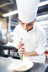 Chef, dessert and plating with professional kitchen, cooking and hospitality industry employee....