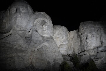 Carved faces atop Mount Rush at night