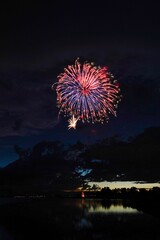 some firework and some sky at night by a body of water