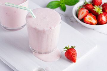 Yogurt , buttermilk or kefir with strawberry. Yogurt in glass on light background. Probiotic cold fermented dairy drink. Gut health, fermented products, healthy gut flora concept