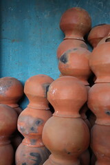 pots are gathered and arranged in a pattern in the empty space. The potter works on a pottery wheel to made of soft colored clay, retro style toned Clay pots with hand and equipment